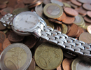 Geldmünzen und eine Armbanduhr